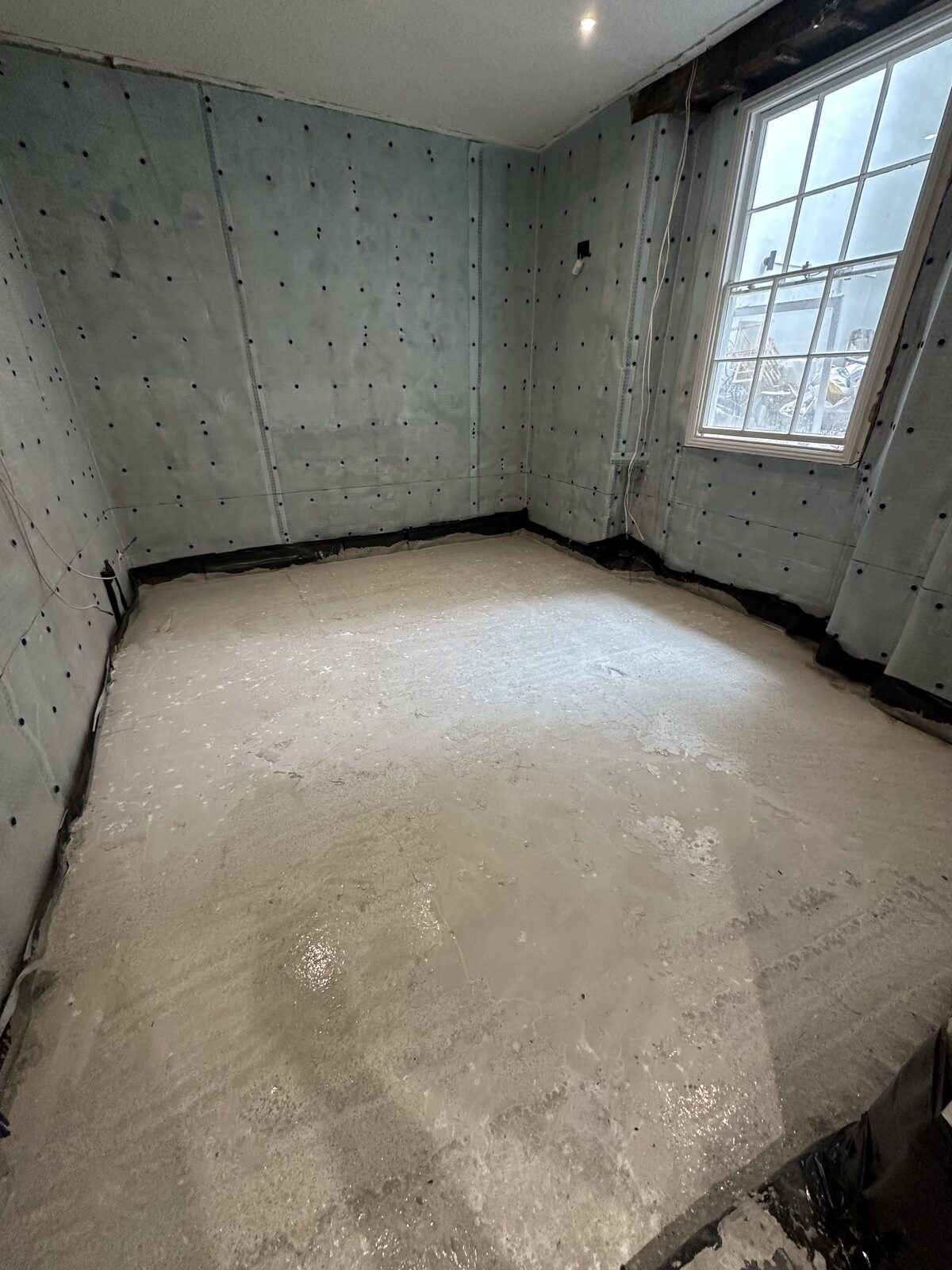 Basement room — membrane and concrete floor with window